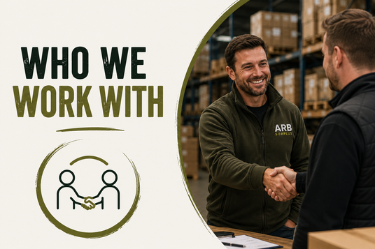 A promotional graphic with the text 'WHO WE WORK WITH' on the left and a photo on the right showing a smiling man in a dark olive green ARB Logistics fleece jacket shaking hands with another person inside a warehouse.
